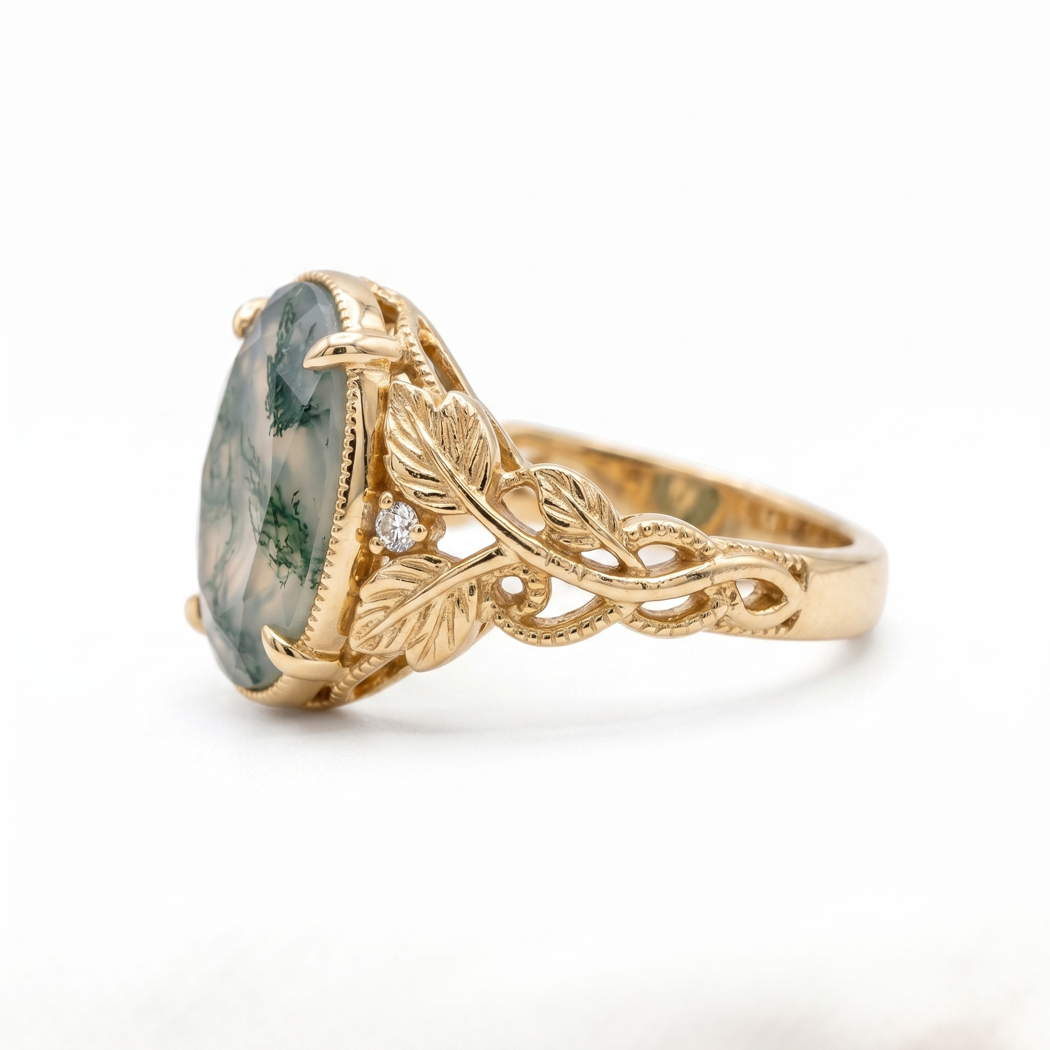 Oval moss agate leaf engagement ring in yellow gold with delicate accent stones
